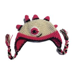 a crocheted hat with horns and eyes is shown in red, white, and black