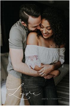 a man and woman embracing each other in front of a bed with the caption love written on it