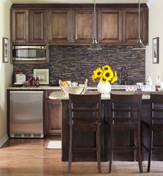 a kitchen filled with wooden cabinets and counter tops next to a silver refrigerator freezer