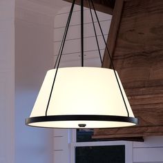 a light fixture hanging from the ceiling in a room with white walls and wood paneling