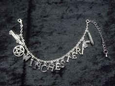 a silver chain bracelet with charms that say witch and the word witches written on it