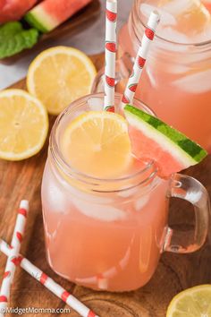 two mason jars filled with watermelon lemonade and topped with slices of watermelon