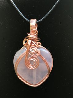 Rose Quartz crystal heart pendant gently wrapped with copper wire.  The heart is like a very pale pink almost cloudy see through stone. I loved wrapping this piece, the unique design is beautiful. Comes with a black necklace 20" with 2" extension. This gemstone is known for its strong vibration of unconditional love, joy, and emotional healing. This gorgeous pink crystal has a powerful energy that resonates within the heart chakra, the area related to compassion.  Powerful to use in meditation a Wire Wrapped Rose Quartz Pendant Necklace, Pink Rose Quartz Wire-wrapped Necklace, Rose Gold Wire Wrapped Pendant Crystal Necklace, Pink Rose Quartz Wire Wrapped Necklace, Wire Wrapped Rose Quartz Necklace Gift, Rose Quartz Wire Wrapped Necklace As Gift, Pink Wire Wrapped Crystal Pendant Necklace, Gift Rose Quartz Wire Wrapped Necklace, Pink Wire Wrapped Necklace For Healing