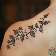 the back of a woman's shoulder with vines and leaves on it