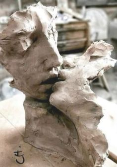 a clay sculpture of a woman's face with the word love written on it