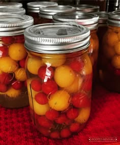 jars filled with cherries sitting on top of a table