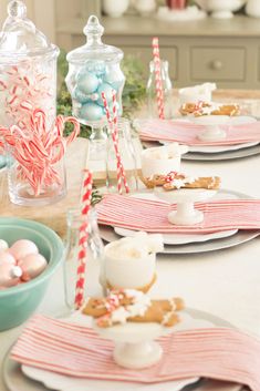 the table is set with candy canes, cookies and marshmallows on it