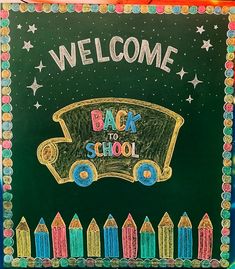 a chalkboard with the words welcome back to school written on it and colorful crayons