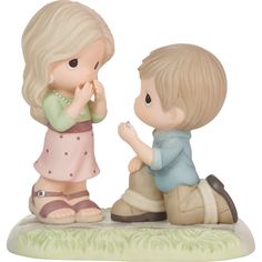 a figurine of two children sitting on the ground with their hands in their mouths