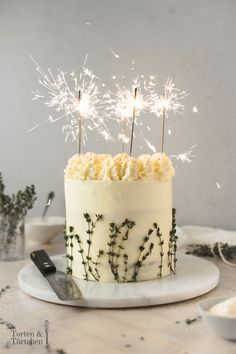 a cake with white frosting and sparklers on top