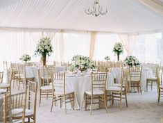 the tables are set with white linens and floral centerpieces for an elegant wedding reception