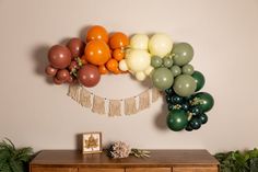 an assortment of balloons are hanging on the wall above a wooden dresser and sideboard