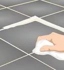 a hand is cleaning the floor with a rag