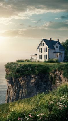 a house sitting on top of a cliff next to the ocean