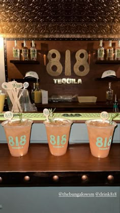 three cups with numbers on them are sitting on a table in front of a bar