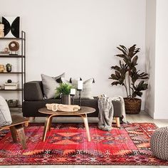 a living room filled with furniture and a rug on the floor in front of a wall