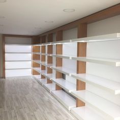 an empty room with white shelves and wood trim