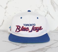 ⚾ Vintage Toronto Blue Jays Script Snapback Hat 🧢  Sports Specialties 90s double line script snapback hat 🕵️ Discoloration around the bottom of the hat and sweatband. Basically anywhere the hat has touched the head. Faint mark on front. Shape is good. Hat has been hygienically cleaned. Vintage Toronto, Vintage Snapback, Snapback Caps, Toronto Blue Jays, Blue Jays, Snapback Cap, Snapback Hat, Snapback Hats, Sun Hats