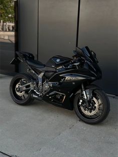 a black motorcycle parked in front of a building