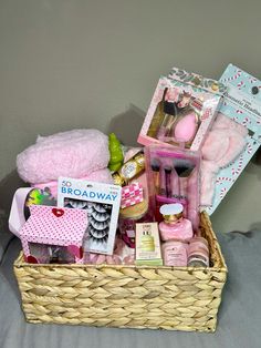 a basket filled with pink items on top of a bed