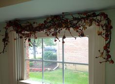 an open window with vines on it in a room that has green walls and white trim