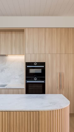 a kitchen with an oven, sink and countertop in wood paneled space between two walls