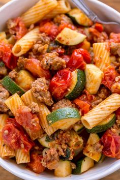 a white bowl filled with pasta and vegetables