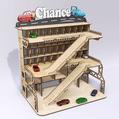 a wooden model of a building with cars on top and the word chance above it