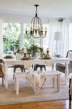 a dining room table with chairs and a chandelier hanging from it's ceiling