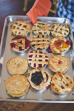 many pies are arranged on a metal tray