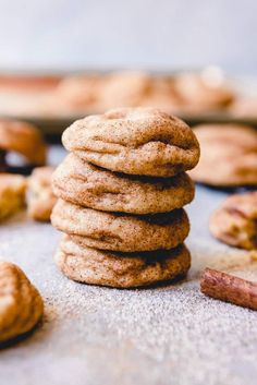 a stack of cookies sitting on top of a counter next to other cookies and cinnamon sticks