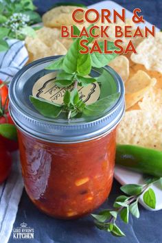 corn and black bean salsa in a mason jar with fresh basil sprigs on top