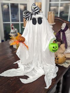 a wooden table topped with halloween decorations and ghost figurines on top of it