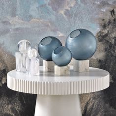 three blue vases sitting on top of a white table next to ice cubes