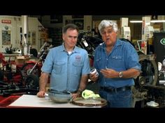 two men standing next to each other in a garage