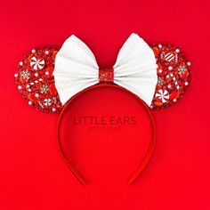 a minnie mouse ears headband with red sequins and white bow on top