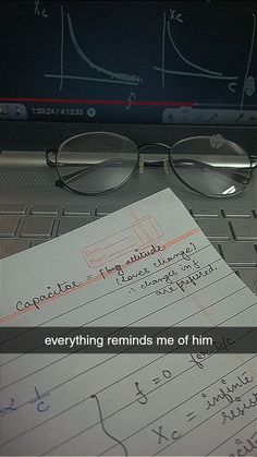 a pair of glasses sitting on top of a paper next to a laptop computer keyboard