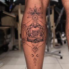 a man's leg with a tattoo on it and a buddha sitting in the center