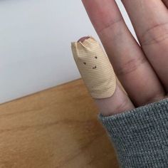 a finger with a bandage on it that has a face drawn on the middle of it