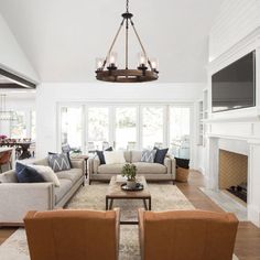 a living room filled with furniture and a flat screen tv mounted to the wall over a fireplace