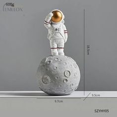 an astronaut statue is shown on top of a gray ball with the measurements for it