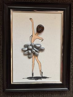 a framed artwork with a ballerina holding rocks