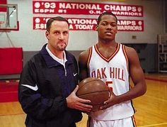 two men standing next to each other holding a basketball