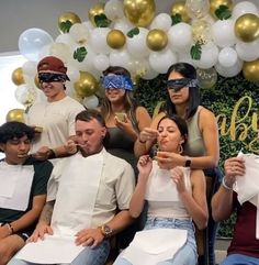 a group of people sitting next to each other with blindfolds on their faces