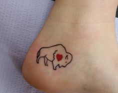 a small elephant with a heart tattoo on its foot