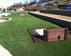 an artificial lawn area with wooden crates on the ground