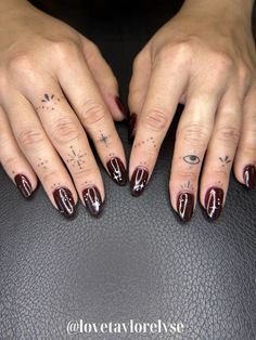 a woman's hands with red and white nail polish on her nails, sitting in front of a black leather surface