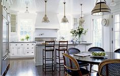 a kitchen filled with lots of counter top space and wooden chairs next to an island