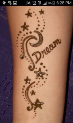 a woman's arm with the word dream written in cursive writing on it