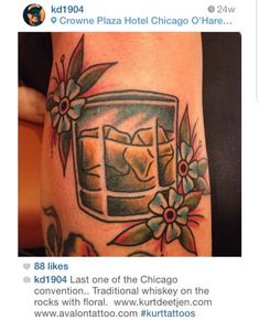 the tattoo on this woman's leg shows an image of a glass with ice and flowers